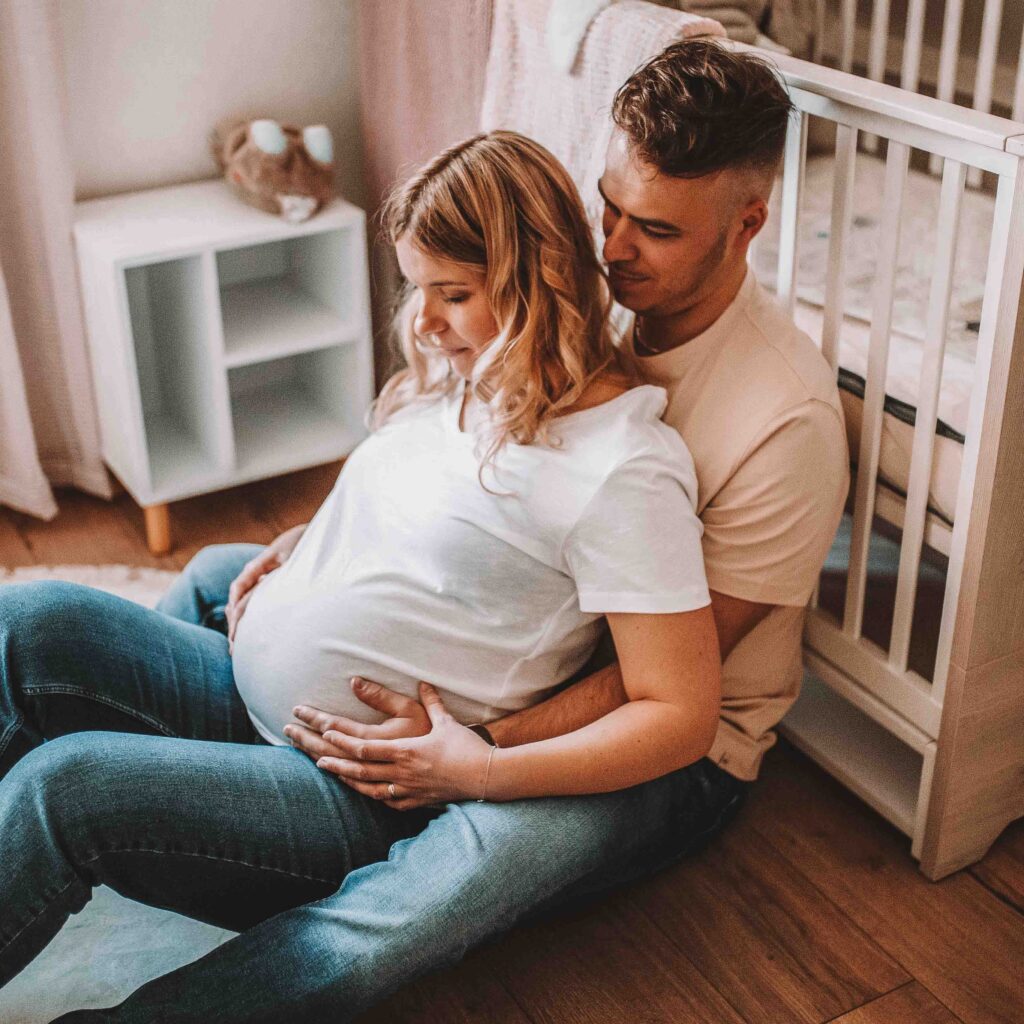 Couple heureux attendant un bébé, séance photo grossesse à domicile en Normandie