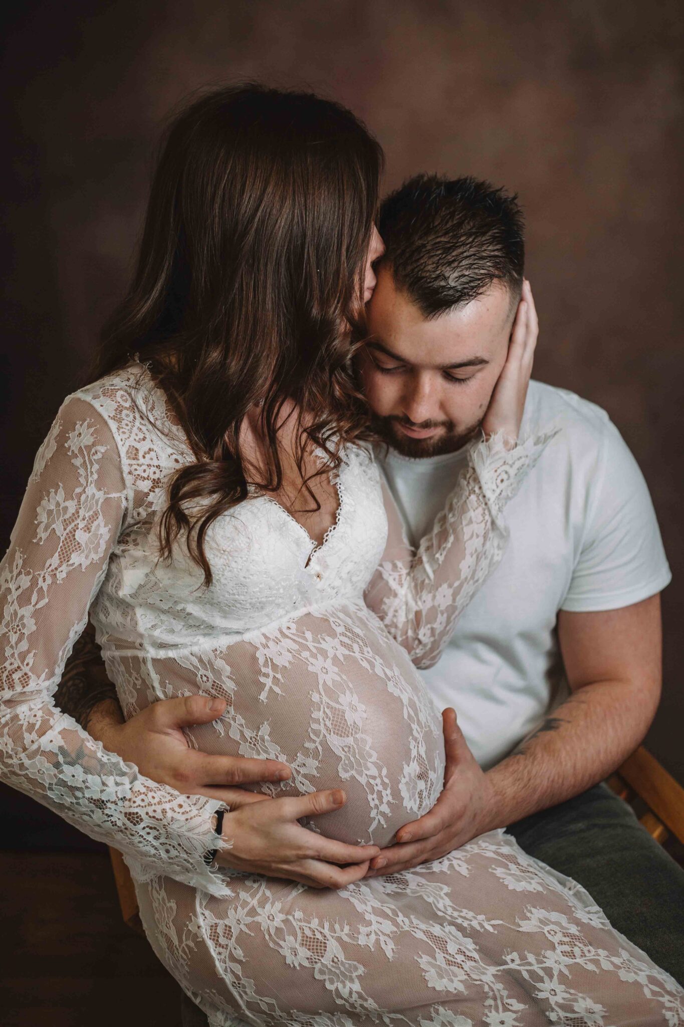 Couple heureux attendant un bébé assis dans un studio photo