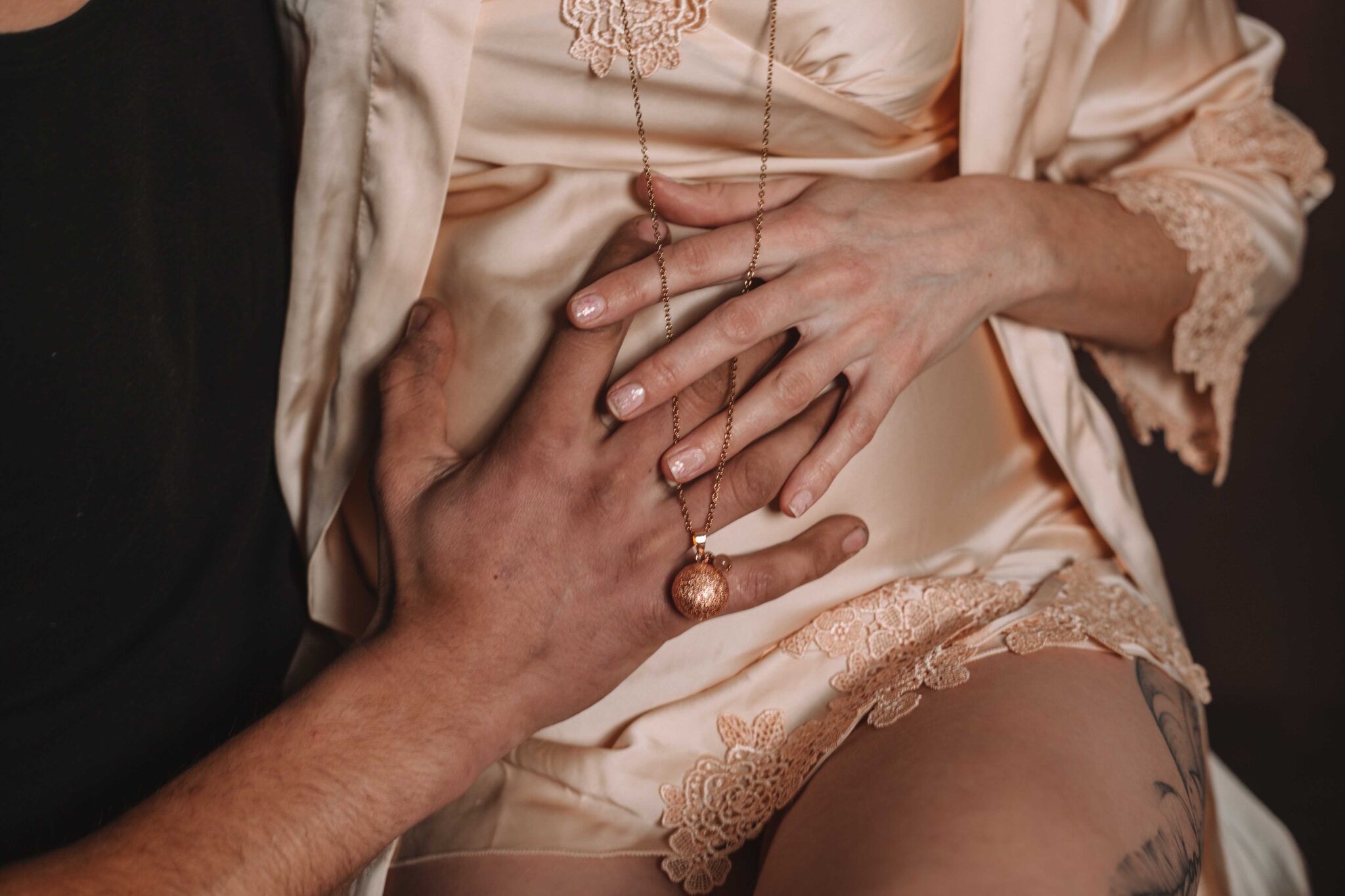 Gros plan sur le ventre arrondi d'une femme enceinte, collier de grossesse