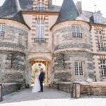 couple de marié face a face devant un sublime chateau d'exception