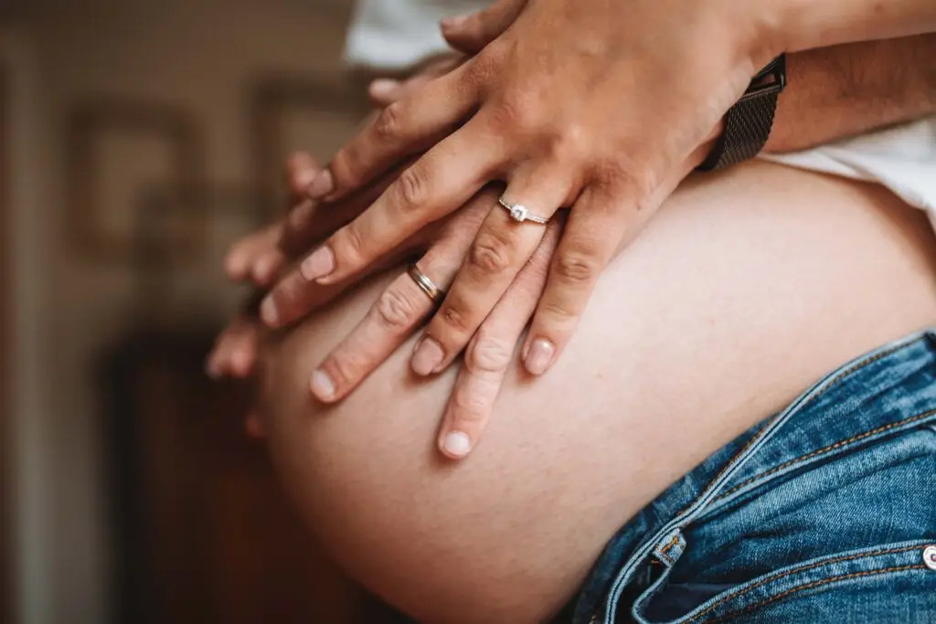 gros plan sur un ventre de grossesse avec les 2 mains du couple posé dessus photographe grossesse Rouen